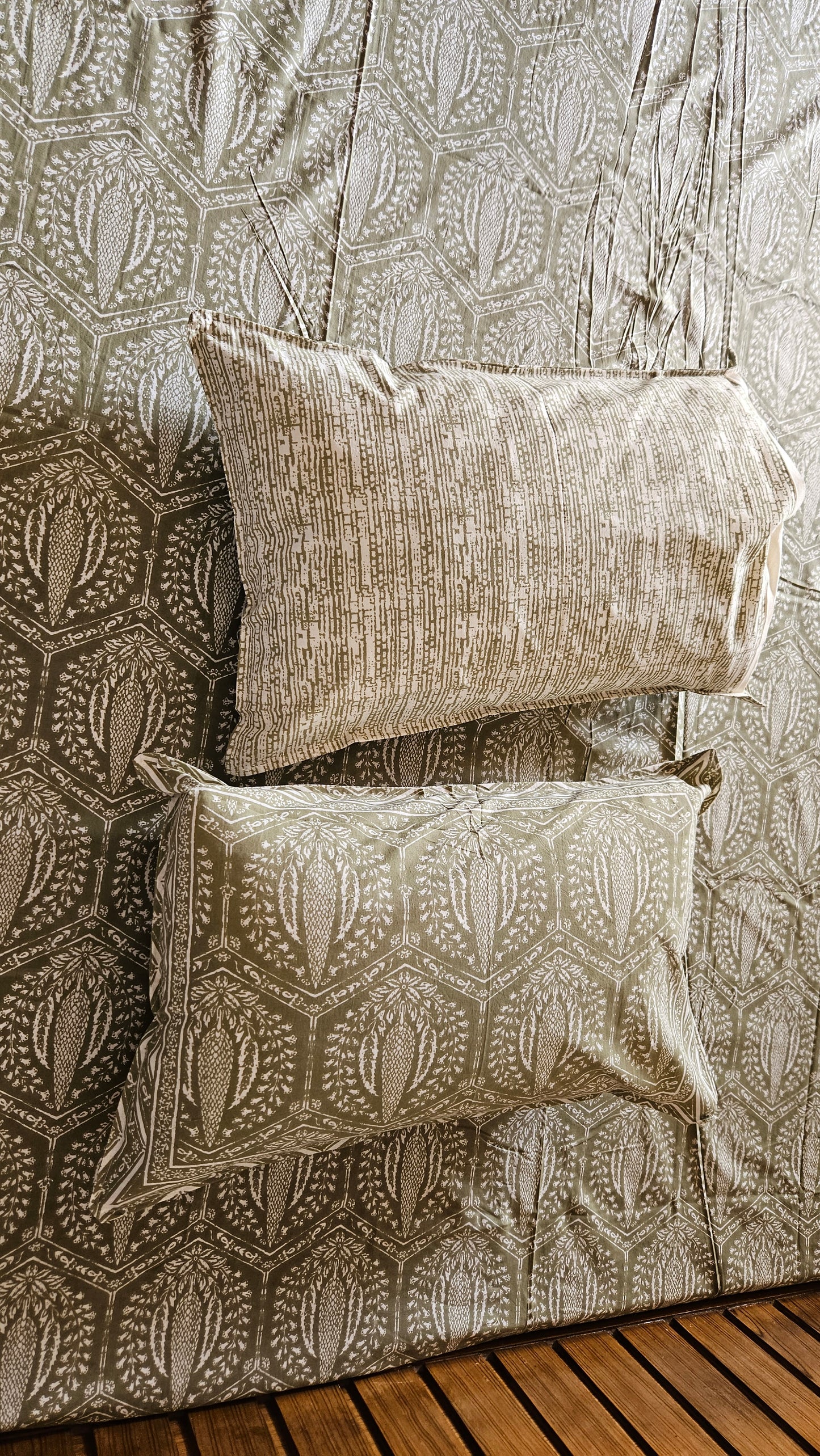 Two patterned pillows on a textured fabric surface