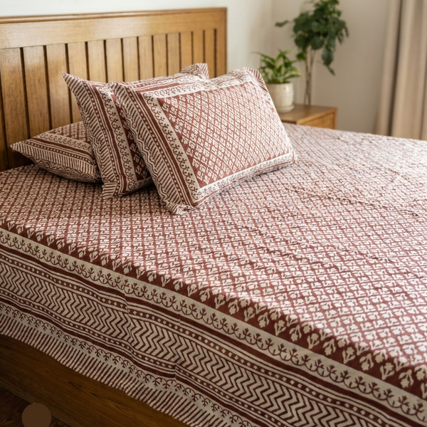 Bed with patterned bedding and pillows in a bedroom setting