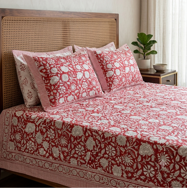 Close-up of Kalakriti Arka Luxe Cotton bedsheet showcasing detailed ivory floral jaal print on a rich red background
