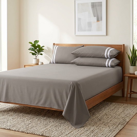Grey bedsheet styled with a wooden bed, rug, wall art and plants